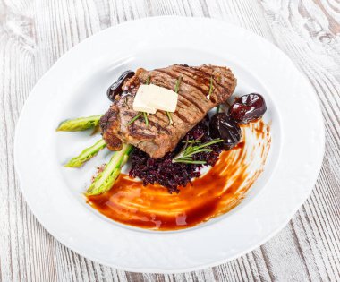 Tatlım, biberiye, kuşkonmaz ve pancar salatası ahşap arka plan üzerinde tarihleri ızgara domuz eti biftek. Sıcak et yemekleri. Üstten görünüm, düz yatıyordu