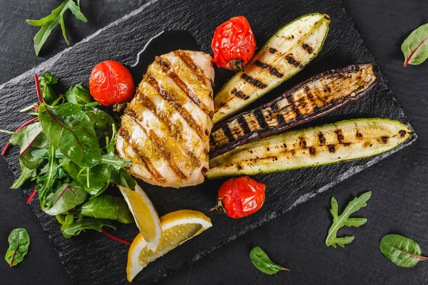 Gegrilltes Fischsteak Garniert Mit Spinatsalat Und Gegrilltem Gemüse Auf Schieferhintergrund — Stockfoto