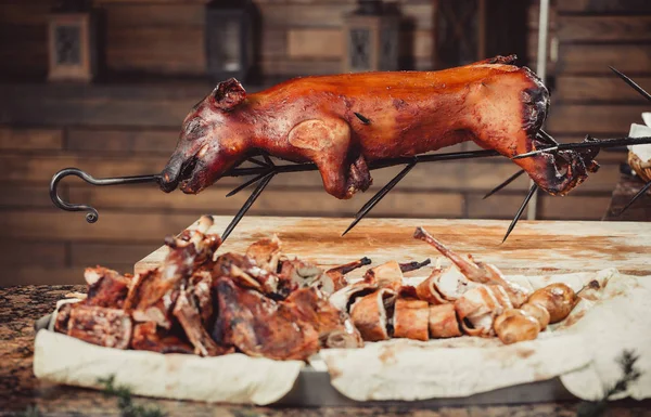 Whole grilled pig with meat steak on cutting board. Hot Meat