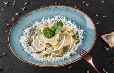 Siyah taş zemin üzerine plaka üzerinde ıspanak ve ricotta Peynirli Ravioli. Yeme, Vejetaryen gıda kavramı temiz. Üstten görünüm, düz yatıyordu