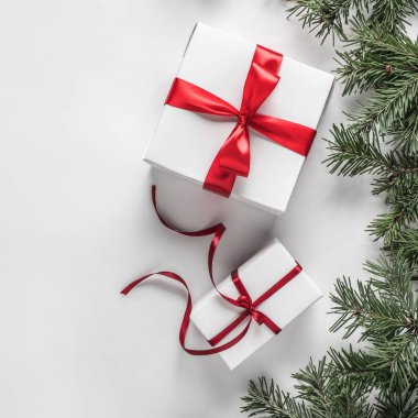 Yaratıcı çerçeve Noel köknar yapılan Beyaz Kağıt arka plan kırmızı dekorasyon, hediye kutuları ile dallarda. Noel ve yeni yıl tema. Düz yatıyordu, en iyi görünümü