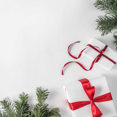 Yaratıcı çerçeve Noel köknar yapılan Beyaz Kağıt arka plan kırmızı dekorasyon, hediye kutuları ile dallarda. Noel ve yeni yıl tema. Düz yatıyordu, en iyi görünümü