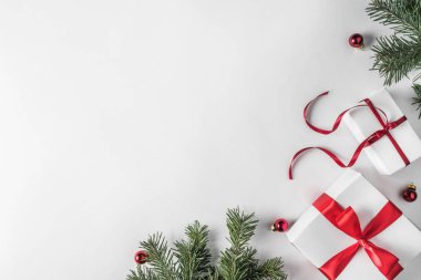 Yaratıcı çerçeve Noel köknar yapılan Beyaz Kağıt arka plan kırmızı dekorasyon, hediye kutuları ile dallarda. Noel ve yeni yıl tema. Düz yatıyordu, en iyi görünümü