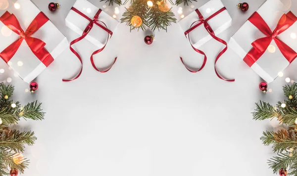 创意框架由圣诞冷杉分支在白纸背景与红色装饰 礼品盒 圣诞节和新年主题 平面布局 顶部视图 — 图库照片
