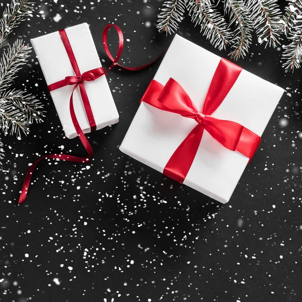 创意布局框架由圣诞树树枝 礼物与红色丝带在黑暗的背景 圣诞节和新年主题 平面布局 顶部视图 — 图库照片