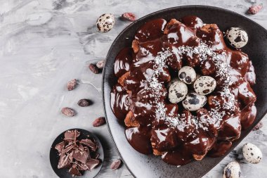 Paskalya kek çikolata, cevizli, bahar çiçekleri, Bıldırcın yumurta taş zemin üzerine. Mutlu Paskalya kutlamaları. Üstten Görünüm, düz yatıyordu.