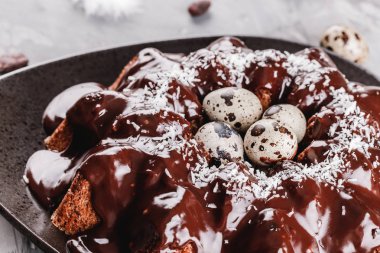 Paskalya kek çikolata, cevizli, bahar çiçekleri, Bıldırcın yumurta taş zemin üzerine. Mutlu Paskalya kutlamaları