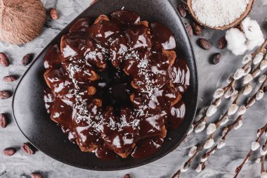 Bir taş zemin üzerine çikolata, bahar çiçekleri ile Paskalya kek. Mutlu Paskalya kutlamaları. Üstten Görünüm, düz yatıyordu