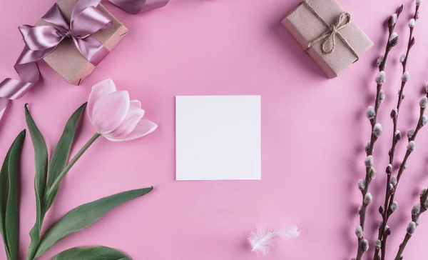 Flor de tulipa rosa e folha de papel sobre fundo rosa claro. Cartão de felicitações ou convite de casamento. Flat lay, vista superior, espaço de cópia — Fotografia de Stock