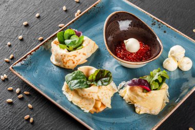 Doldurulmuş Krep kırmızı havyar, tereyağı ve Yeşiller plaka ile tepesinde. Bir koyu gri taş yüzeye görüntüleyin. Krep hafta ya da Shrovetide. Sağlıklı kahvaltı. Üstten Görünüm, düz yatıyordu