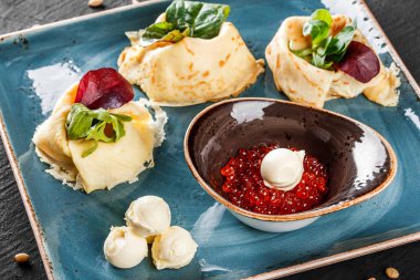 Doldurulmuş Krep kırmızı havyar, tereyağı ve Yeşiller plaka ile tepesinde. Bir koyu gri taş yüzeye görüntüleyin. Krep hafta ya da Shrovetide. Sağlıklı kahvaltı. Üstten Görünüm, düz yatıyordu