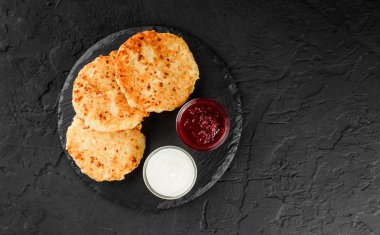 Krep meyve reçeli, kiraz, ekşi krema ve koyu arka plan üzerinde krema şeker üzerinde siyah arduvaz ile. Hafta ya da Shrovetide krep geleneksel Rus mutfağı. Sağlıklı kahvaltı. Üstten Görünüm