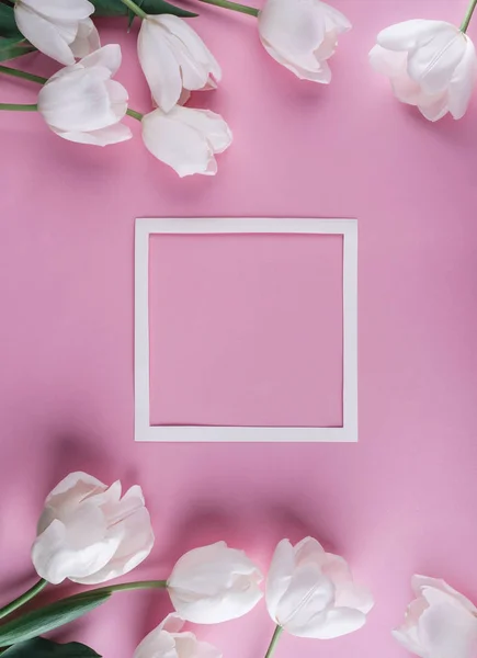 Flores de tulipas brancas e folha de papel sobre fundo rosa claro. Cartão para o Dia das Mães, 8 de Março, Feliz Páscoa. À espera da Primavera. Cartão de felicitações ou convite de casamento. Deitado plano, vista superior — Fotografia de Stock