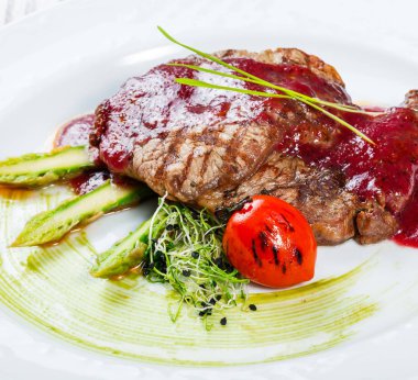 Izgara antrikot Biftek Biftek berry sos, kuşkonmaz ve brokoli hafif ahşap zemin üzerinde. Sıcak et yemekleri. Üstten görünüm, düz yatıyordu.