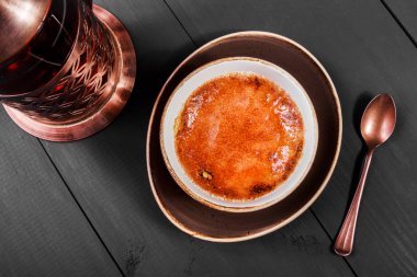 Creme brulee ya da koyu arka plan üzerinde çay caramelised şeker ile Fransız vanilya krem tatlı