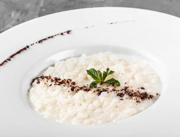 Porridge de riz avec chocolat râpé en assiette sur fond gris. Des ingrédients sains pour le petit déjeuner. Alimentation propre, concept alimentaire végétalien . — Photo