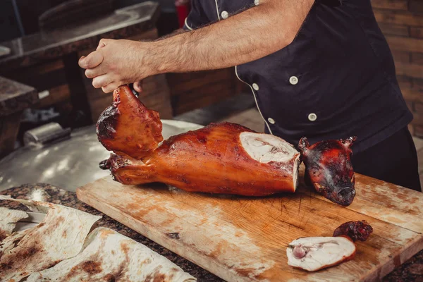 Chef Mãos cortando porco grelhado grelhado para bifes com faca na tábua de corte. Pratos de carne quente . — Fotografia de Stock