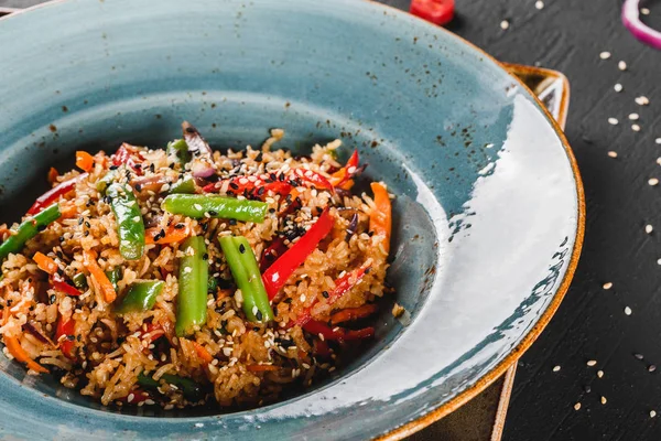 Spaghettis de pâtes à la sauce, ragoût de légumes et graines dans une assiette sur une table en pierre foncée. . — Photo