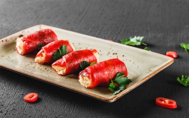 Peynir ve ekşi krema koyu taş zemin üzerine rulo fırında biber dolması. Temiz Yeme Vejetaryen yiyecekler.