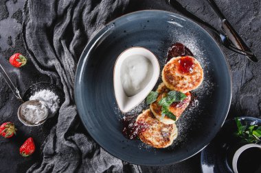 Krep Meyve reçeli, çilek, ekşi krem, nane ve gri arka plan üzerinde plaka üzerinde buzlanma şekeri. Pancake haftası veya shrovetide 'de geleneksel Rus mutfağı. Sağlıklı kahvaltı