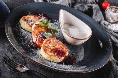 Krep Meyve reçeli, çilek, ekşi krem, nane ve gri arka plan üzerinde plaka üzerinde buzlanma şekeri. Pancake haftası veya shrovetide 'de geleneksel Rus mutfağı. Sağlıklı kahvaltı