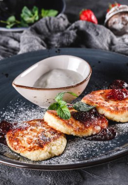 Krep Meyve reçeli, çilek, ekşi krem, nane ve gri arka plan üzerinde plaka üzerinde buzlanma şekeri. Pancake haftası veya shrovetide 'de geleneksel Rus mutfağı. Sağlıklı kahvaltı