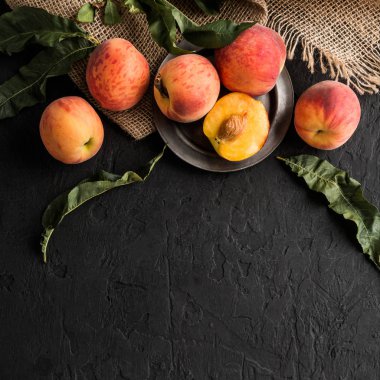 Olgun şeftali siyah taş zemin üzerine. Sağlıklı gıda kavramı, üstten görünüm, kopya alanı.