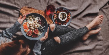 Yün kazak ve vegan pilav Hindistan cevizi lapası incir, çilek, fındık yemek kot kadında. Sağlıklı kahvaltı malzemeler. Yeme, vegan gıda kavramı temiz