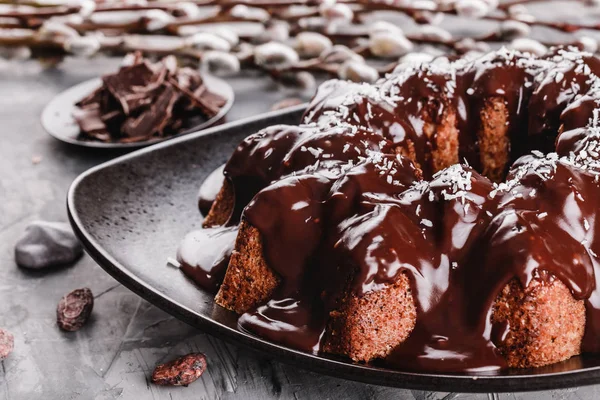 Paskalya kek çikolata, Hindistan cevizi, bir taş zemin üzerine bahar çiçekleri ile. Mutlu Paskalya kutlamaları.