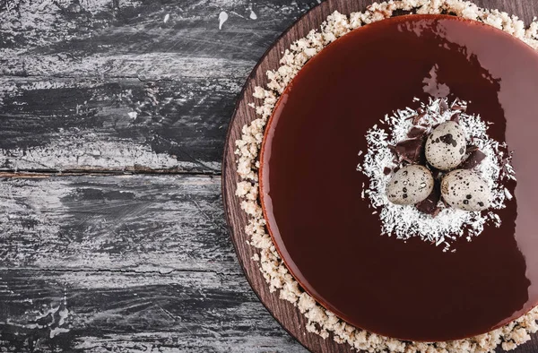 Påsk kaka med spegel glasyr choklad, kokos, vårblommor, vaktelägg på rustika bakgrund. Glad påskfirande. Ovanifrån, platt låg — Stockfoto