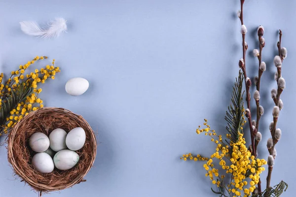 Пасхальні яйця в гніздо і Весняні квіти на тлі синього свято. Вітальна листівка для щасливого Великдень. Плоскі мирян, top погляд. — стокове фото