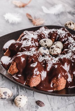 Paskalya kek çikolata, cevizli, bahar çiçekleri, Bıldırcın yumurta taş zemin üzerine. Mutlu Paskalya kutlamaları. Üstten Görünüm, düz yatıyordu