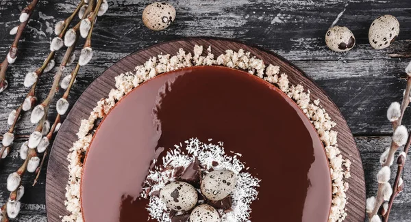 Påsk kaka med spegel glasyr choklad, kokos, vårblommor, vaktelägg på rustika bakgrund. Glad påskfirande. Ovanifrån, platt låg — Stockfoto