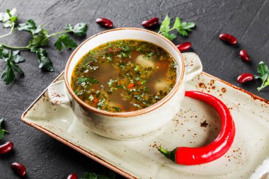 Fasulye, sebze, koyu taş arka plan tabakta otlar ile Çorba. Temiz beslenme, sağlıklı gıda konsepti. Üstte görüntü.