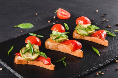 Meze bruschetta sebze, domates ve baharat siyah şeyl üzerinde siyah taş zemin kurulu. Sağlıklı gıda kavramı.
