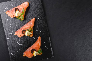Somon fileto, zeytin ve limon ciabatta ekmeği taş arduvaz arka plan üzerinde üzerinde meze bruschetta. Sağlıklı gıda kavramı.