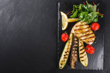 Ispanak salatası ile süslenmiş ızgara balık biftek