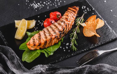 Ispanak, limon, otlar ile süslenmiş ızgara somon fileto