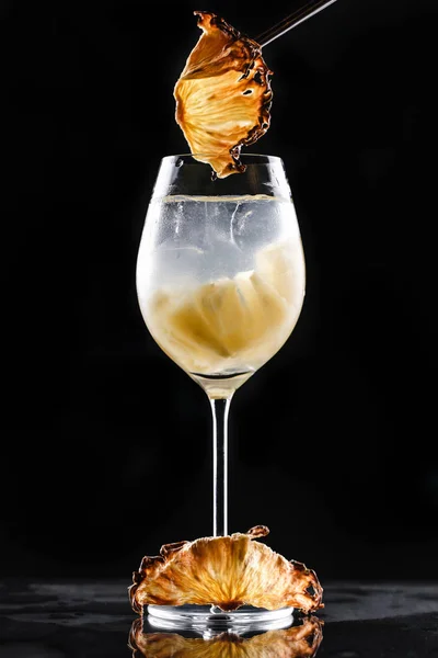Холодный коктейль с ананасом и льдом в высоком стакане на черном фоне. Летние напитки и алкогольные коктейли . — стоковое фото