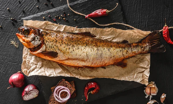 Pesce trota affumicato, pesce intero rosso con spezie e cipolla — Foto Stock