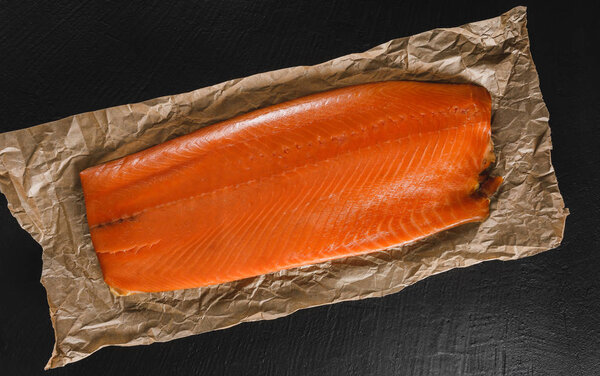 Smoked fillet salmon, red fish steak on craft paper