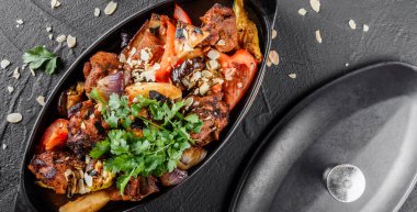 Tavada ızgara sebze, yeşillik ve badem ile fırında et 