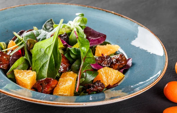 Salat mit Leber, Rucola, Orange, Spinat und Mandeln auf Teller — Stockfoto