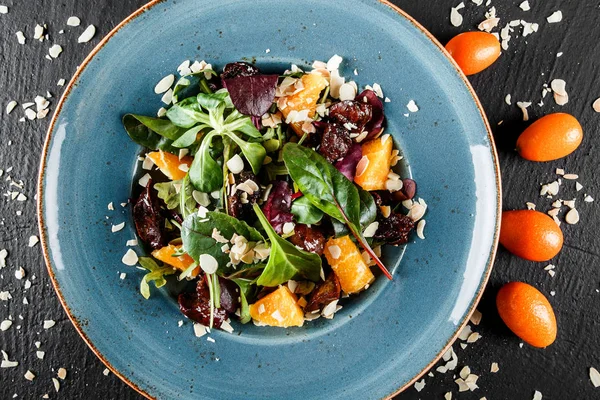 Salat mit Leber, Rucola, Orange, Spinat und Mandeln auf Teller — Stockfoto