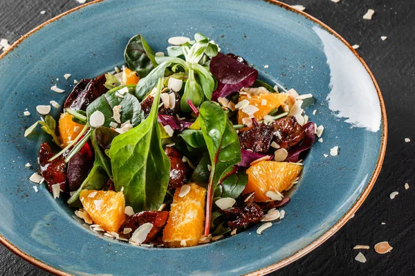 Salat mit Leber, Rucola, Orange, Spinat und Mandeln auf Teller — Stockfoto