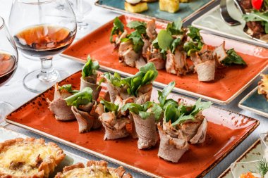 Banquet masada tabakta pişmiş jambon, krem peynir ve yeşillik ile et rulo. Catering gıda, kanepe ve aperatifler.