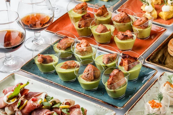 Filete de carne a la parrilla con mousse verde en copas de vidrio sobre mesa de banquete. Comida para catering, canapé y aperitivos —  Fotos de Stock