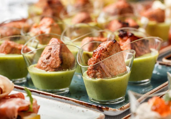 연회 테이블에 유리 컵에 녹색 무스와 구운 고기 필레. 케이터링 음식, 카나페 및 스낵 — 스톡 사진