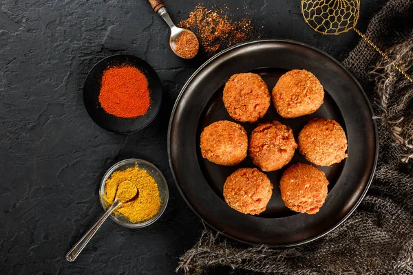 Bolas de queso de patata frita o croquetas con especias en plato negro sobre fondo de piedra oscura. Comida poco saludable, vista superior . —  Fotos de Stock