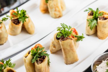 Doldurulmuş Krep, ziyafet masasında tabak içinde et ve sebzeler ile tepesinde. Gurme yemekleri yakın, meze tabağı. Sağlıklı kahvaltı.